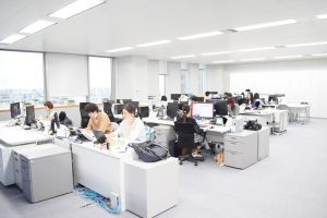 開放感のある執務エリア。奥のキャビネットも目立たない白にしてあり、パーティションもなくしてコミュニケーションが取りやすい環境となっている。窓からは高層ビルならではのすばらしい景色が広がる